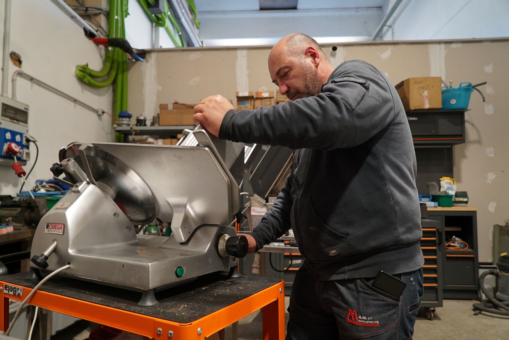 Tecnico A.M. ripara un'affettatrice in officina